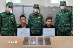 Hai đối tượng Đào Mạnh Hà và Nông Hoài Lâm cùng tang vật bị lực lực đánh án bắt giữ. (Ảnh: TTXVN phát)