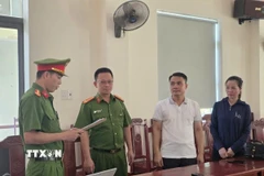 Thi hành Lệnh khởi tố bị can đối với Vũ Ngọc Liêm và Ngô Thị Tuyết. (Ảnh: TTXVN phát)