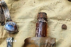 Hài cốt liệt sỹ được tìm thấy kèm di vật kèm có ghi dòng chữ đặc biệt. (Ảnh: TTXVN phát)