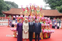 Tổng Bí thư Tô Lâm và Phu nhân cùng Tổng thống Pháp Emmanuel Macron và Phu nhân với các nghệ sĩ biểu diễn Nhã nhạc Cung đình Huế. (Ảnh: Thống Nhất/TTXVN)