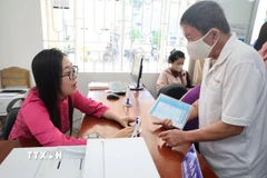 Cán bộ hướng dẫn cho người dân đến thực hiện thủ tục hành chính tại phường Vũng Tàu, Thành phố Hồ Chí Minh. (Ảnh: Hoàng Nhị/TTXVN)