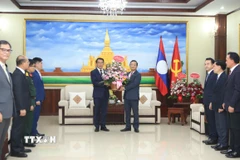 Đại sứ Nguyễn Minh Tâm chuyển lẵng hoa của Tổng Bí thư Việt Nam Tô Lâm chúc mừng 71 năm Ngày thành lập Đảng Nhân dân Cách mạng Lào. (Ảnh: Xuân Tú/TTXVN)