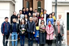 Tham tán Hà Thị Lâm Hồng (thứ ba từ phải sang hàng đầu tiên) chụp ảnh lưu niệm cùng các tri thức Việt tại Berlin và vùng phụ cận. (Ảnh: Phương Hoa/TTXVN)