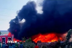 Lửa bùng phát dữ dội tại nhà xưởng bông của Chi nhánh Công ty Trách nhiệm hữu hạn Thương phẩm Á Phi (khu Hợp Thành, phường Yên Tử). (Ảnh: TTXVN phát)