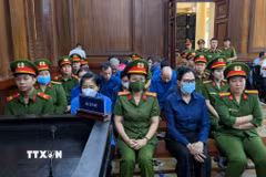 Bị cáo Lê Thúy Hằng (cựu Tổng Giám đốc SJC, người đeo khẩu trang, hàng đầu) bị tuyên mức án 25 năm tù. (Ảnh: TTXVN phát)