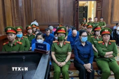 Bị cáo Lê Thúy Hằng (cựu Tổng Giám đốc SJC, người đeo khẩu trang, hàng đầu) bị tuyên mức án 25 năm tù. (Ảnh: TTXVN phát)