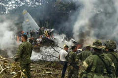 Các binh sĩ quân đội và người dân vây quanh chiếc máy bay gặp nạn. (Nguồn: AFP)