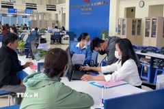 Cán bộ Trung tâm Phục vụ-Kiểm soát thủ tục hành chính tỉnh Quảng Ngãi hướng dẫn trực tiếp người dân đến làm thủ tục hành chính. (Ảnh: Hải Âu/TTXVN)