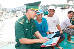 Đồn biên phòng Thanh Hải tổ chức tuyên truyền chống khai thác IUU cho ngư dân tại cảng Phú Hài, phường Phú Thủy (tỉnh Lâm Đồng). (Ảnh: Nguyễn Thanh/TTXVN)
