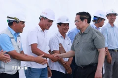 Thủ tướng Phạm Minh Chính với kỹ sư, công nhân thi công Dự án đường bộ cao tốc Châu Đốc-Cần Thơ-Sóc Trăng giai đoạn 1. (Ảnh: Dương Giang/TTXVN)