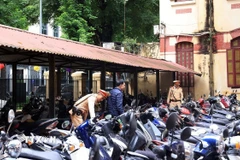 Lực lượng chức năng phối hợp với Ban Giám hiệu các trường tiến hành kiểm tra khu vực bãi gửi xe trong trường THPT Trần Phú-Hoàn Kiếm (Hà Nội). (Ảnh: Tuấn Anh/TTXVN)