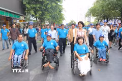 Thứ trưởng Bộ Y tế Nguyễn Thị Liên Hương và ông Nguyễn Mạnh Cường, Phó Chủ tịch Ủy ban Nhân dân Thành phố Hồ Chí Minh, cùng các đại biểu và người khuyết tật đi bộ đồng hành nhân Lễ kỷ niệm Ngày Người khuyết tật Việt Nam. (Ảnh: Thanh Vũ/TTXVN)