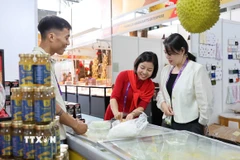Đại diện doanh nghiệp Việt Nam giới thiệu sản phẩm bánh sầu riêng Việt Nam. (Ảnh: Công Tuyên/TTXVN)