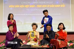 Giới thiệu và trải nghiệm làm tranh Đông Hồ với khán giả. (Ảnh: Nguyễn Thu Hà/TTXVN)