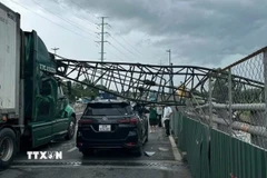 Cần cẩu thi công đè trúng hai xe ôtô trên cầu vượt Mỹ Thủy, thành phố Thủ Đức. (Ảnh: TTXVN phát)