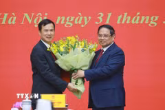 Thủ tướng Phạm Minh Chính tặng hoa chúc mừng ông Bùi Thế Duy giữ chức Giám đốc Đại học Quốc gia Hà Nội. (Ảnh: Dương Giang/TTXVN)