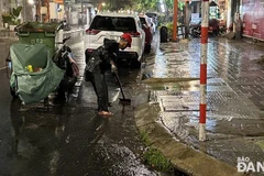 Công nhân dọn vệ sinh trên đường phố và khơi thông thoát nước sau khi nước rút vào rạng sáng 12/6. (Nguồn: Báo Đà Nẵng)
