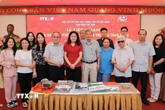 Bà Nguyễn Thị Sự, Ủy viên Ban Thường vụ Đảng ủy, Phó Tổng giám đốc TTXVN, chụp ảnh lưu niệm cùng Phóng viên lão thành và thân nhân của người trao tặng hiện vật. (Ảnh: Lê Đông/TTXVN)