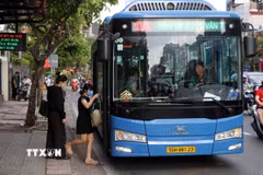 Người dân đón xe buýt trên đường Cộng Hòa, hướng vào trung tâm Thành phố Hồ Chí Minh sáng 6/4. (Ảnh: Tiến Lực/TTXVN)