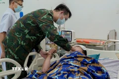 Các bác sỹ tích cực cấp cứu cho người bệnh tại Trạm xá đảo Sinh Tồn. (Ảnh: TTXVN phát)