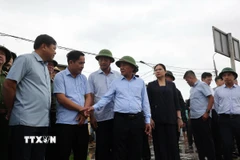 Ông Trần Cẩm Tú, Thường trực Ban Bí thư nghe báo cáo tình hình gia cố, bảo vệ bờ kè tại thôn An Lương bị sạt lở uy hiếp đến tính mạng tài sản của hàng trăm hộ dân xã Duy Nghĩa. (Ảnh: Anh Dũng/TTXVN)