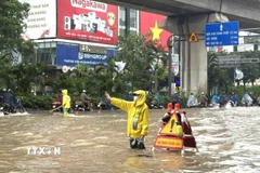 Công nhân làm nhiệm vụ thoát nước tại khu vực ngập sâu trên đường Nguyễn Trãi (Hà Nội). (Ảnh: Quốc Lũy/TTXVN)