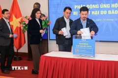 Viên chức, người lao động TTXVN ủng hộ đồng bào miền Trung, Tây Nguyên khắc phục hậu quả mưa lũ. (Ảnh: Hoàng Hiếu/TTXVN)