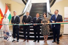 Đại biểu hai nước Việt Nam và Hungary thực hiện nghi thức cắt băng khai mạc triển lãm ảnh. (Ảnh: Trung Tuyến/TTXVN)