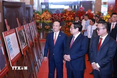 Thủ tướng Phạm Minh Chính tham quan trưng bày ảnh về quá trình hình thành và phát triển của Đài Tiếng nói Việt Nam. (Ảnh: Dương Giang/TTXVN)