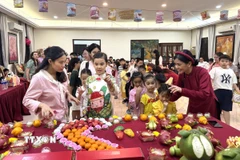 Các em nhỏ xếp hàng phá cỗ Trung Thu. (Ảnh: Viên Luyến/TTXVN)