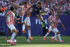 Tiền đạo Kylian Mbappe (số 10) của Pháp liên tục bị các cầu thủ Paraguay kèm chặt. (Ảnh: AFP/TTXVN)