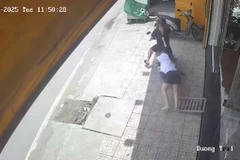 Nữ nhân viên của tiệm vàng bị nghi can cướp kéo lê. (Ảnh cắt từ camera an ninh)