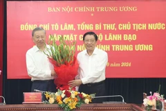 Đồng chí Phan Đình Trạc, Ủy viên Bộ Chính trị, Bí thư Trung ương Đảng, Trưởng Ban Nội chính Trung ương, Phó Trưởng ban Thường trực Ban Chỉ đạo Trung ương về phòng, chống tham nhũng, lãng phí, tiêu cực tặng hoa Tổng Bí thư, Chủ tịch nước Tô Lâm. (Ảnh: Trí Dũng/TTXVN)