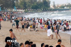 Bãi biển Đồi Dương, thành phố Phan Thiết (Bình Thuận) đông nghịt du khách tắm biển. (Ảnh: Nguyễn Thanh/TTXVN)