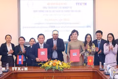 Tổng Giám đốc Thông tấn xã Việt Nam Vũ Việt Trang ký kết thỏa thuận hợp tác nghiệp vụ với Tổng Giám đốc Thông tấn xã Pathet Lào Vannasin Simmavong. (Ảnh: Văn Điệp/TTXVN)