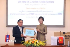 Tổng giám đốc Thông tấn xã Việt Nam Vũ Việt Trang trao tặng phẩm tặng Thông tấn xã Pathet Lào. (Ảnh: Văn Điệp/TTXVN)