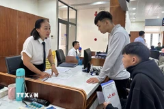 Cán bộ Trung tâm hành chính công phường Tam Kỳ, thành phố Đà Nẵng, hướng dẫn người dân làm thủ tục hành chính. (Ảnh: Trần Tĩnh/TTXVN)