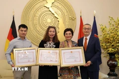 Đại sứ Vũ Quang Minh trao Giấy khen cho các phóng viên thường trú TTXVN tại Berlin. (Ảnh: PV TTXVN tại Đức)