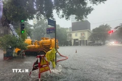 Khẩn trương tiêu thoát nước trên đường Bà Triệu. (Ảnh: Nguyễn Thắng/TTXVN)