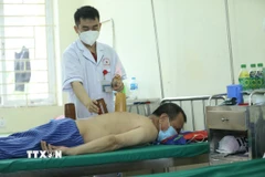 Sử dụng phương pháp giác hơi điều trị cho bệnh nhân. (Ảnh: Anh Tuấn/TTXVN)