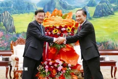 Đặc phái viên của Tổng Bí thư Tô Lâm, ông Lê Hoài Trung chúc mừng Tổng Bí thư Ban Chấp hành Trung ương Đảng Nhân dân cách mạng Lào khóa XII, Chủ tịch nước Lào Thongloun Sisoulith. (Ảnh: Xuân Tú/TTXVN)