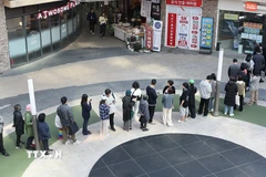 Người dân xếp hàng chờ để thay thế thẻ SIM tại một đại lý của SK Telecom sau khi xảy ra vụ tấn công mạng. (Ảnh: Yonhap/TTXVN)