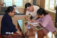 Nhân viên Trung tâm phục vụ hành chính công xã Duy Xuyên, thành phố Đà Nẵng, hướng dẫn người dân thực hiện các yêu cầu về thủ tục hành chính. (Ảnh: Đoàn Hữu Trung/TTXVN)