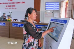 Người dân bấm số thứ tự để làm thủ tục hành chính tại Trung tâm phục vụ hành chính công xã Xuân Hồng, Ninh Bình. (Ảnh: Công Luật/TTXVN)