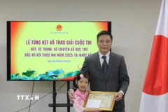 Bé Kim Trà My nhận Giấy khen từ lãnh đạo Đại sứ quán Việt Nam tại Nhật Bản. (Ảnh: Phạm Tuân/TTXVN)
