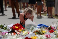 Người dân đặt hoa tưởng niệm các nạn nhân trong vụ xả súng tại bãi biển Bondi ở Sydney, Australia. (Ảnh: THX/TTXVN)