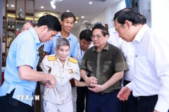 Thủ tướng Phạm Minh Chính thăm, tặng quà thương binh Nguyễn Xuân Viên, cựu tù Côn Đảo. (Ảnh: Dương Giang/TTXVN)