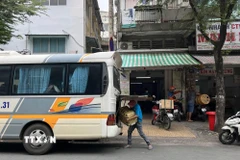 Giao nhận hàng hóa trước vị trí số 34C Nguyễn Duy Dương, nơi được liệt kê là “xe dù, bến cóc.” (Ảnh: Tiến Lực – TTXVN)