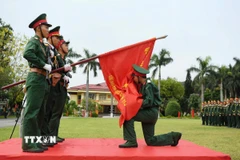 Chiến sỹ mới của Lữ đoàn 113 đặc công hôn Lá cờ Quyết thắng của đơn vị trong lễ tuyên thệ. (Ảnh: Trọng Đức/TTXVN)