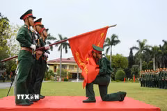 Chiến sỹ mới của Lữ đoàn 113 đặc công hôn Lá cờ Quyết thắng của đơn vị trong lễ tuyên thệ. (Ảnh: Trọng Đức/TTXVN)
